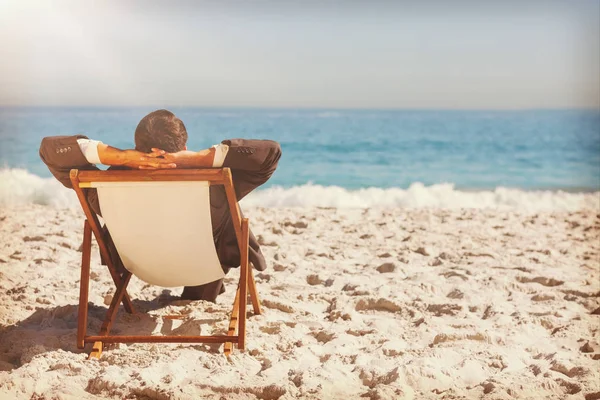 Businessman relaxing on his sun lounger — Stock Photo, Image