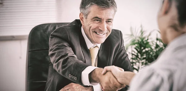 Man shaking a womans hand in an office — Stock Photo, Image