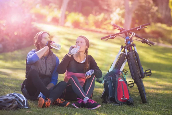 Pareja ciclista relajándose y tomando agua — Foto de Stock