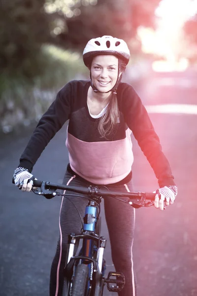 Motociclista femenina con bicicleta de montaña en el campo — Foto de Stock