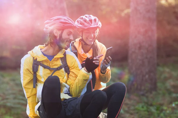 Pareja ciclista usando teléfono móvil — Foto de Stock