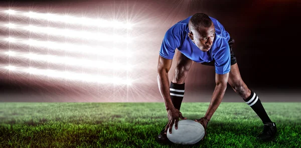 Jogador de rugby segurando bola enquanto joga — Fotografia de Stock