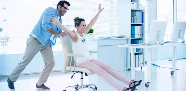 Photo editors having fun with on a swivel chair — Stock Photo, Image