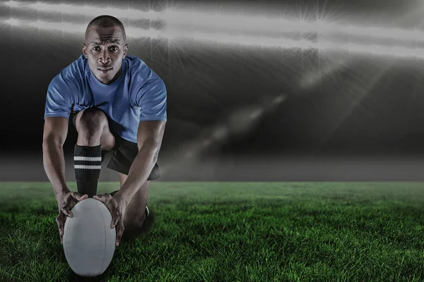 Jogador de rugby ajoelhado e segurando bola — Fotografia de Stock