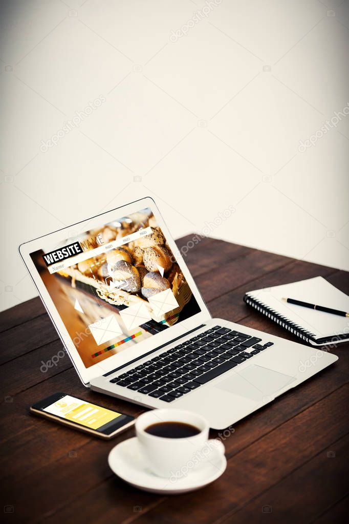Homepage of a website against laptop personal organizer and belongings on table