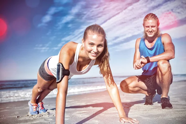 Portrait of couple exercising on sand — Stock Photo, Image