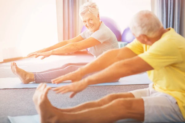 Seniors stretching legs — Stock Photo, Image