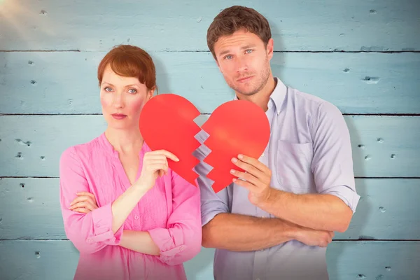 Pareja sosteniendo un corazón roto — Foto de Stock