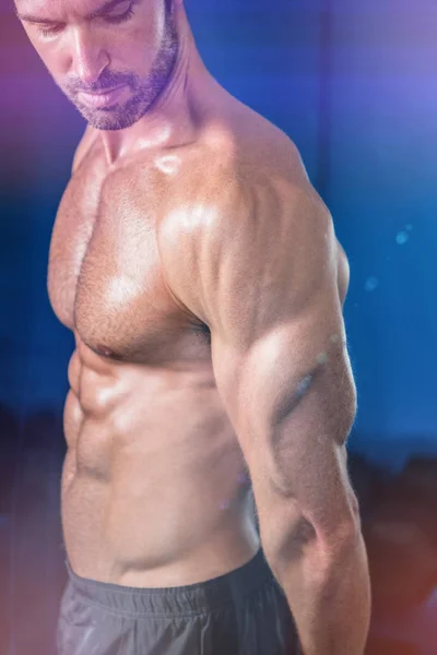 Shirtless athlete looking at biceps — Stock Photo, Image