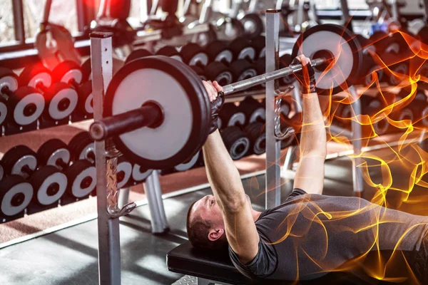 Muskulös man lyft barebell liggande på bänken — Stockfoto