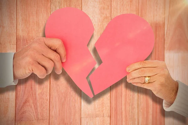 Casal segurando um coração papel quebrado — Fotografia de Stock