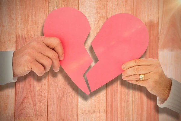 Pareja sosteniendo un corazón de papel roto —  Fotos de Stock