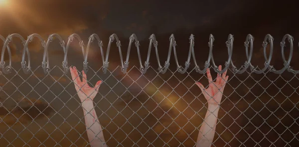 Man with arms raised on chainlink fence — Stock Photo, Image