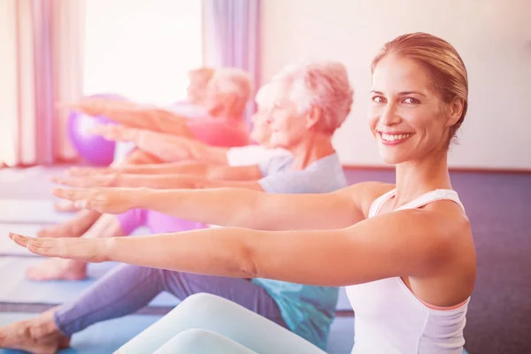 Porträtt av instruktör utför yoga med seniorer — Stockfoto