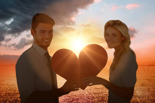 Atractiva pareja joven sosteniendo el corazón — Foto de Stock