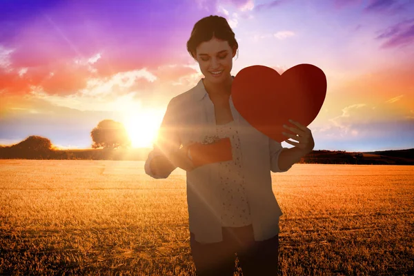 Mujer sosteniendo un regalo y tarjeta de corazón — Foto de Stock