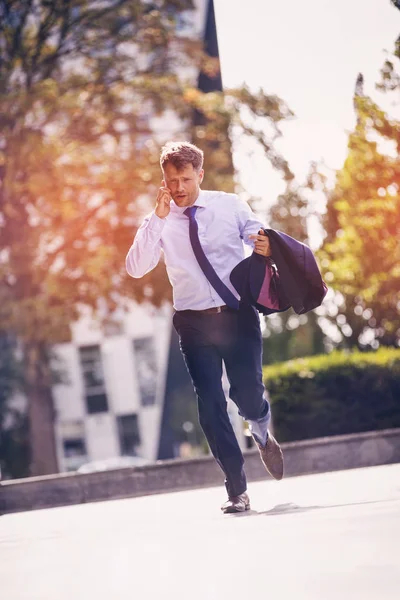 Handsome businessman talking on mobile phone at street — Stock Photo, Image