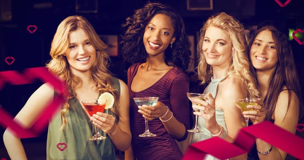 Friends having a drink against hearts — Stock Photo, Image