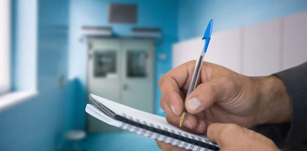 Man writing in spiral book — Stock Photo, Image