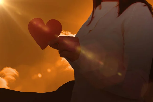 Женщина держит бумагу в форме сердца — стоковое фото
