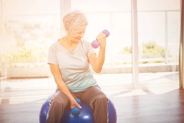 Dumbbell tutarak gülümseyen kadın kıdemli — Stok fotoğraf