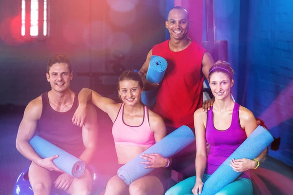 Retrato de amigos sonrientes sosteniendo colchonetas de ejercicio — Foto de Stock