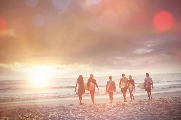 Happy friends walking with surfboards — Stock Photo, Image