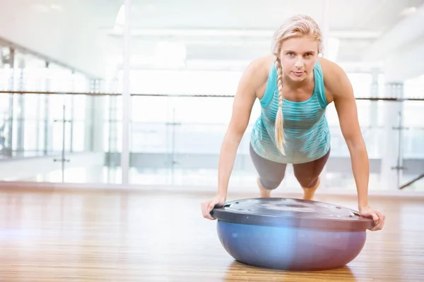 Portrait of fit woman doing push up on bosu ball — Stock Photo, Image