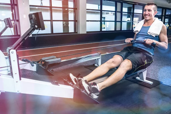 Hombre muscular usando máquina de remo —  Fotos de Stock