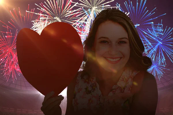 Woman holding heart card and blowing kiss — Stock Photo, Image