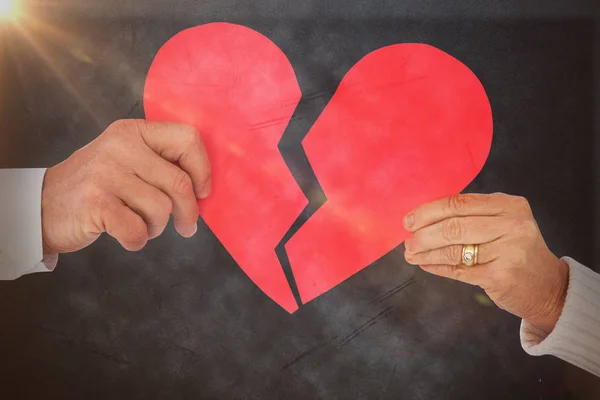 Casal segurando um coração de papel quebrado — Φωτογραφία Αρχείου