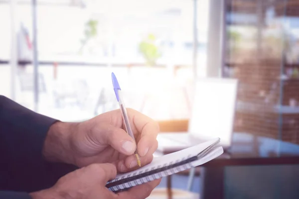 Man writing in spiral book — Stock Photo, Image