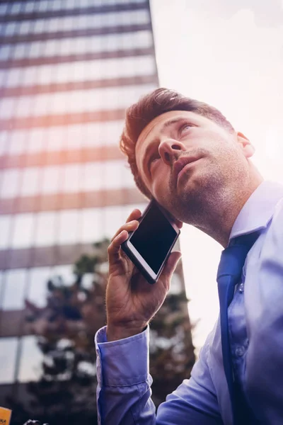 Vista de bajo ángulo del hombre de negocios guapo hablando en el teléfono móvil — Foto de Stock