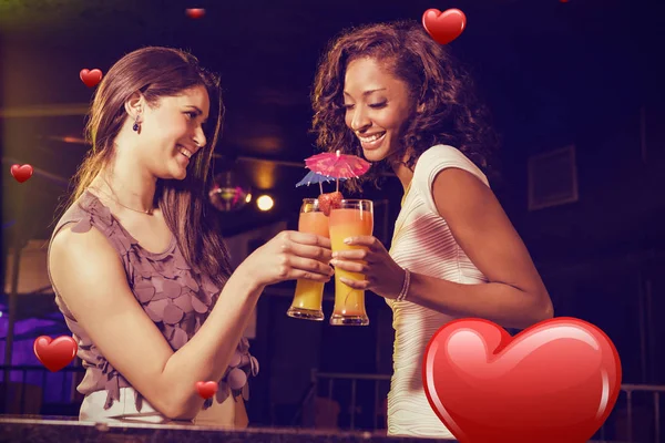 Women having cocktails against hearts — Stock Photo, Image