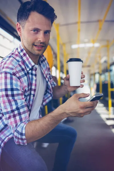 Retrato de homem bonito usando telefone celular enquanto toma café — Fotografia de Stock