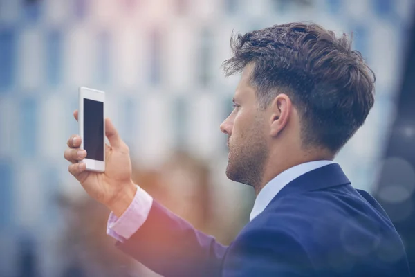 Biznesmen patrząc na telefon komórkowy — Zdjęcie stockowe