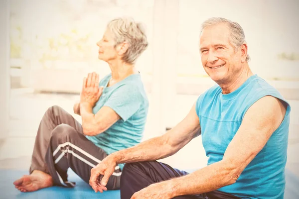 Hombre mayor sentado al lado de la esposa realizando yoga —  Fotos de Stock