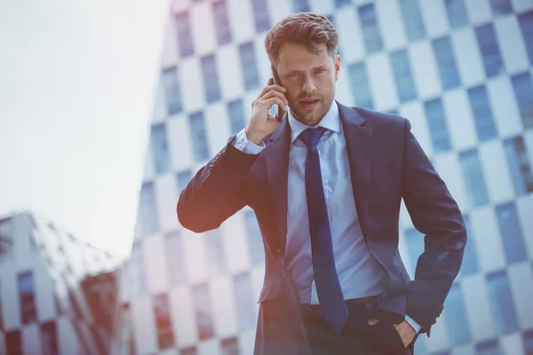 Låg vinkel syn på säker affärsman talar på mobiltelefon — Stockfoto