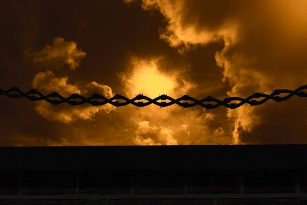 Barbed wire against cloudy sky — Stock Photo, Image