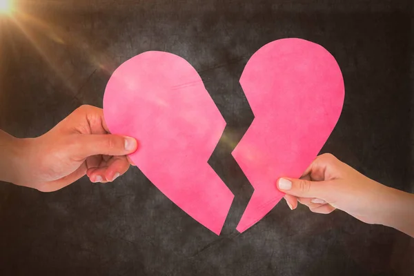 Couple holding halves of broken heart — Stock Photo, Image