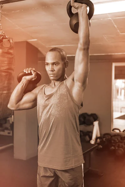 Atleta masculino joven haciendo ejercicio con pesas —  Fotos de Stock