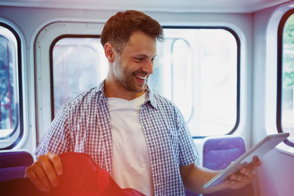 Homem alegre usando tablet digital no trem — Fotografia de Stock