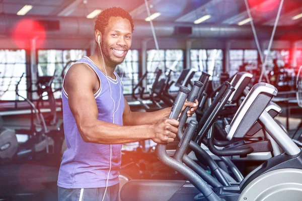 Hombre sonriente haciendo ejercicio con auriculares — Foto de Stock