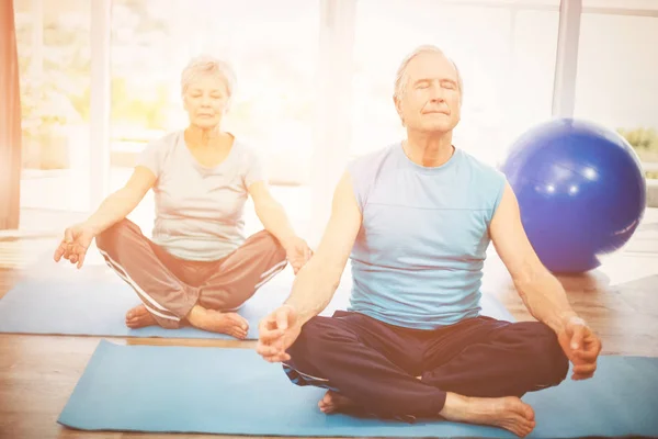 Casal sênior meditando em casa — Fotografia de Stock