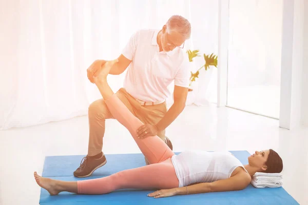 Physiotherapist stretching pregnant lady leg — Stock Photo, Image