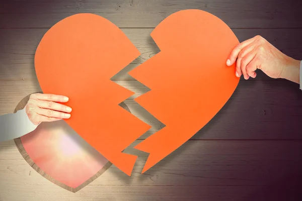 Casal segurando papel em forma de coração quebrado — Fotografia de Stock