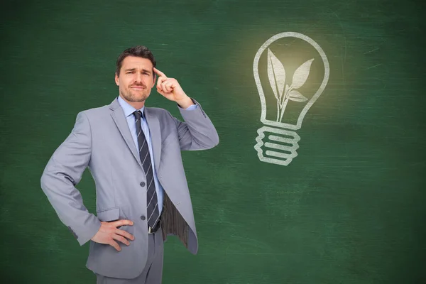 Thinking businessman against chalkboard — Stock Photo, Image