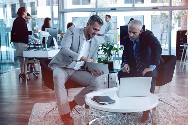 Hombres de negocios discutiendo mientras usa la tableta —  Fotos de Stock