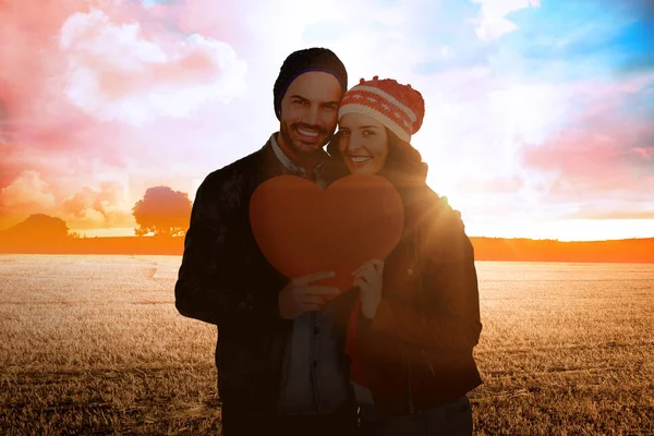 Casal segurando papel em forma de coração — Fotografia de Stock