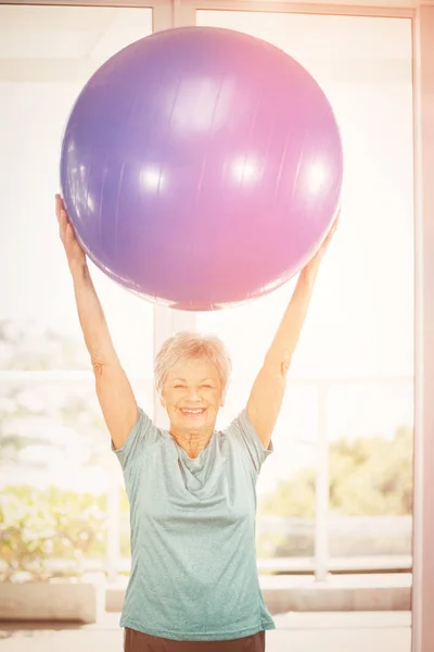 Portrait of happy woman holding blue exercise ball — Stock Photo, Image
